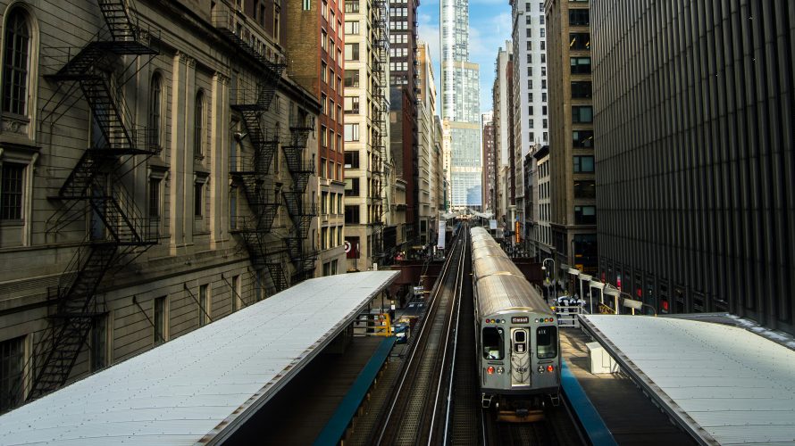 A train departs a downtown stop midday in Chicago.
