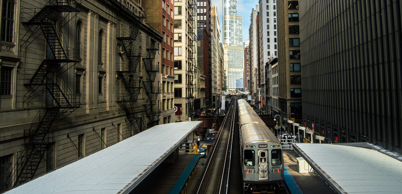 A train departs a downtown stop midday in Chicago.