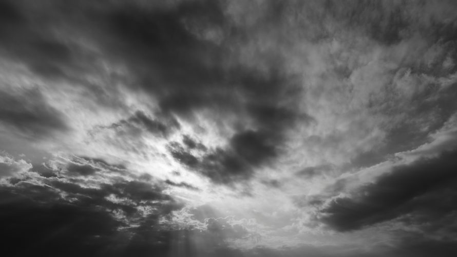 Light breaking through storm clouds symbolizing courage and clarity from keynote speaker on leadership and courage Ryan Berman